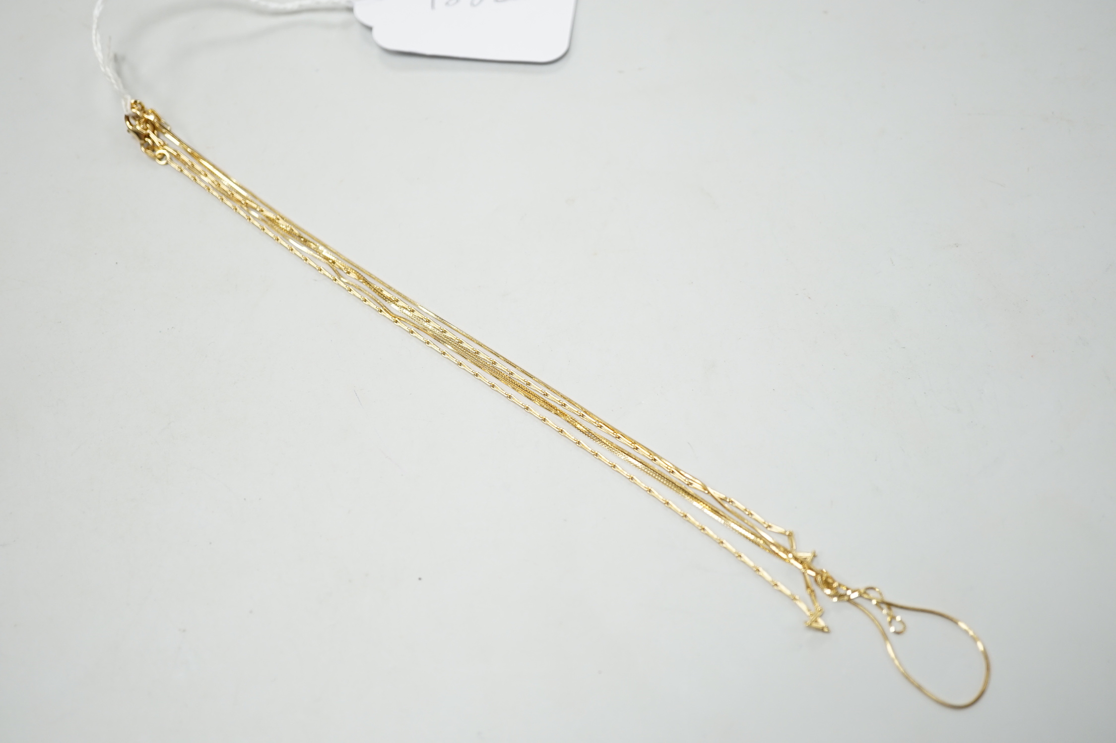 An 18ct gold fine baton link chain, 38cm and one other 750 chain, 7.3 grams and one 14kt chain, 0.9 grams.